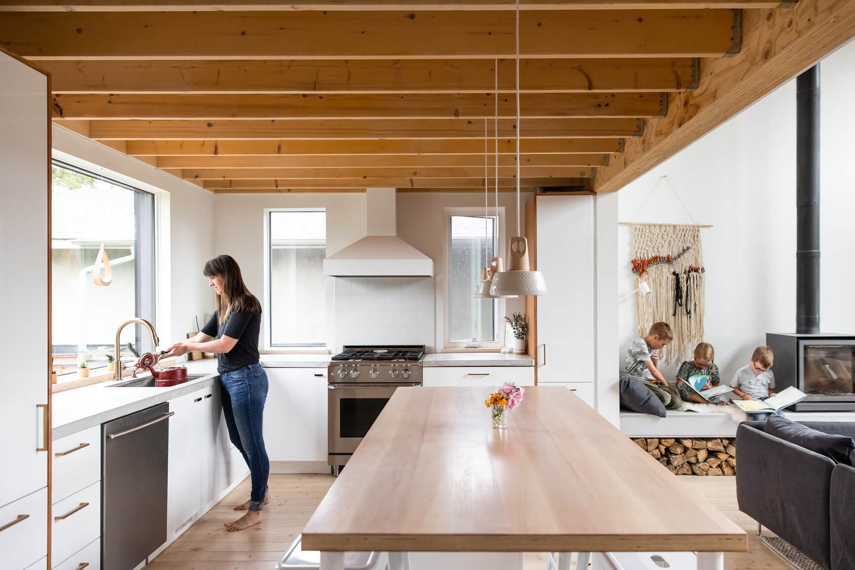 Bright modern kitchen with homeowner at the sink